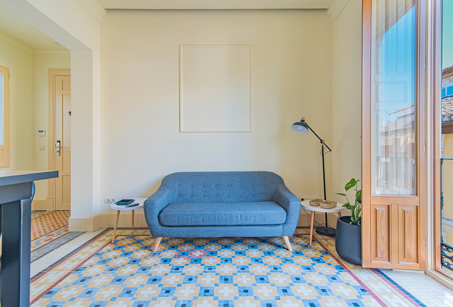 Sofá de diseño de color azul sobre suelo original de mosaiko