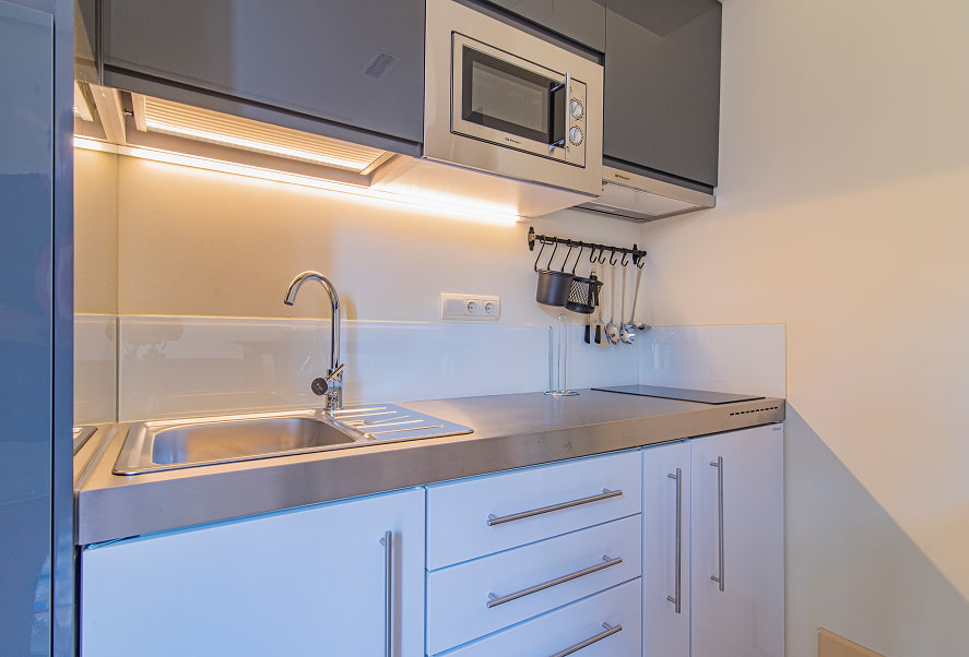 Cocina completa equipada con microondas, fogones y menaje