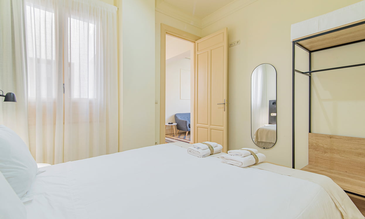 Dormitorio doble decorado en tonos blancos y crema