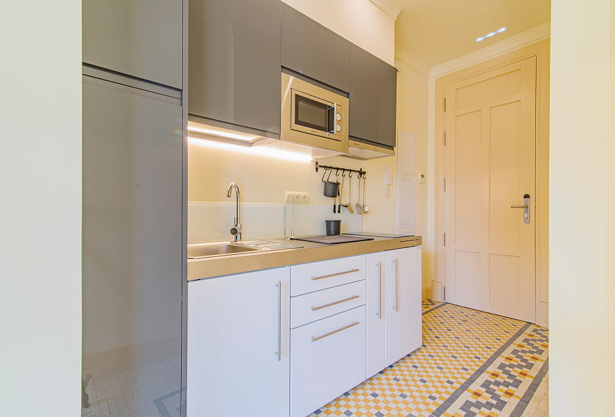 Cocina equipada con microondas, fogones y menaje de cocina