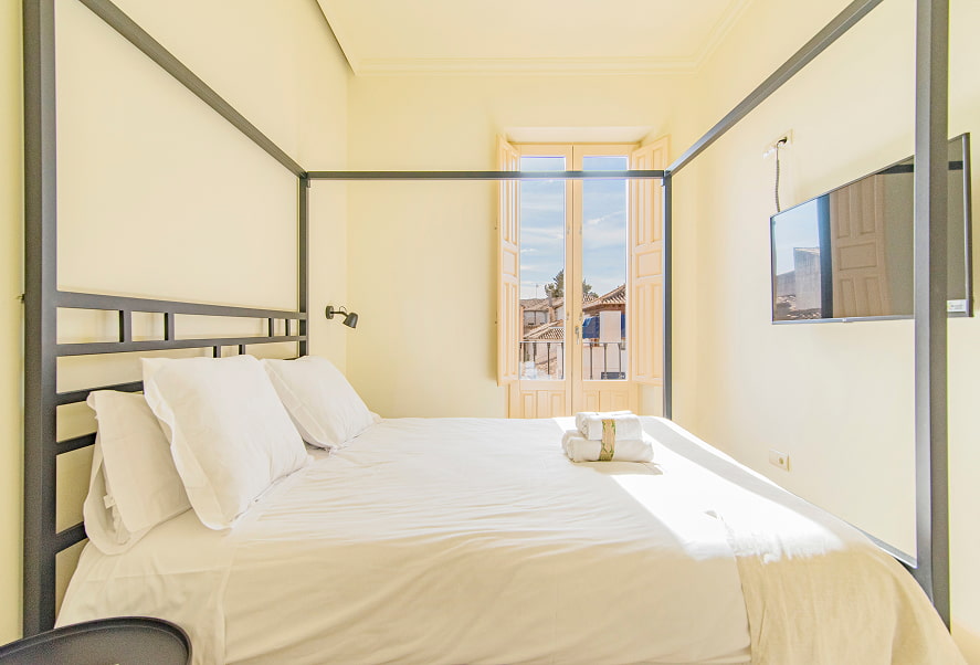 Vita lateral del dormitorio doble con dosel, con vistas a la ciudad