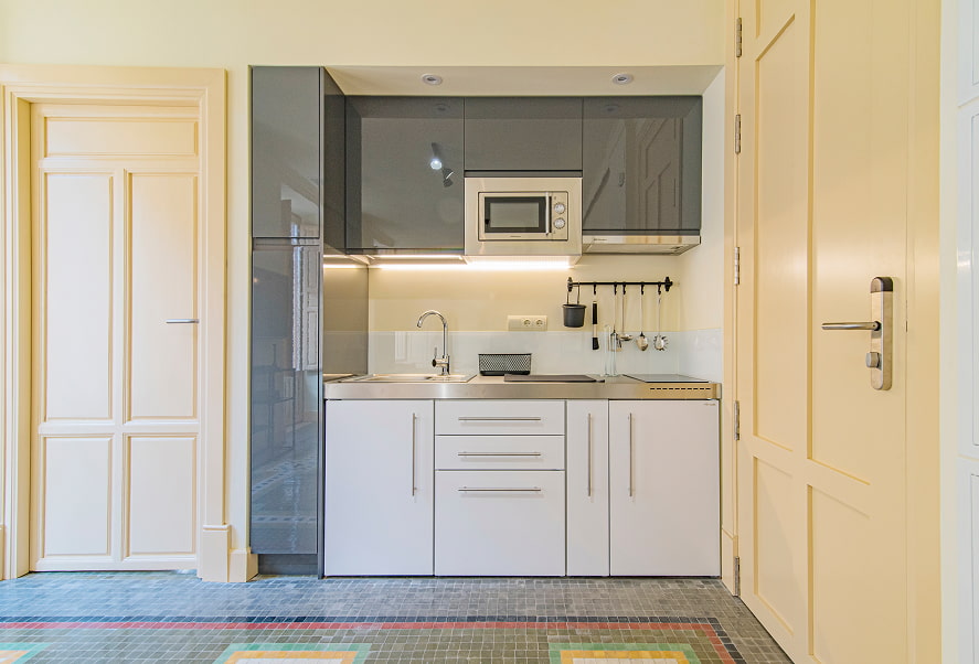 Cocina equipada con microondas, fogones y menaje de cocina