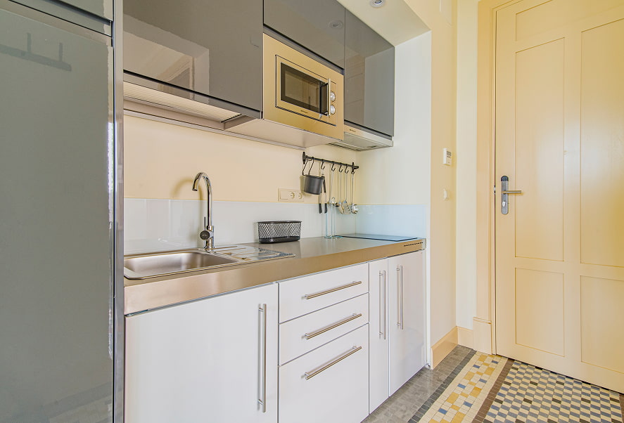 Cocina equipada con microondas, fogones y menaje de cocina