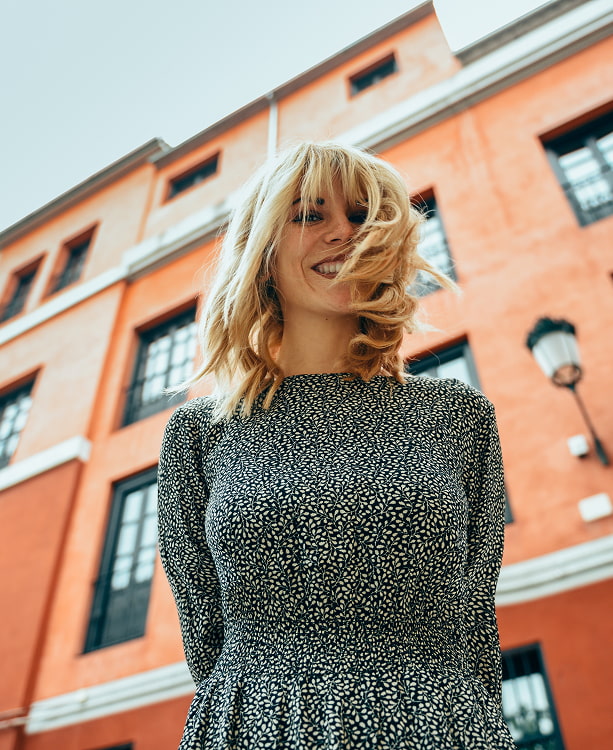 Mujer sonriendo con edificios de la ciudad de fondo